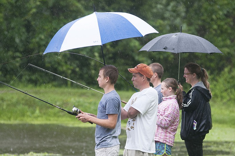 The Gaines Family of Fulton fishes underneath umbrellas Saturday during the Alan Leake Fishing Tournament at Veterans Park.