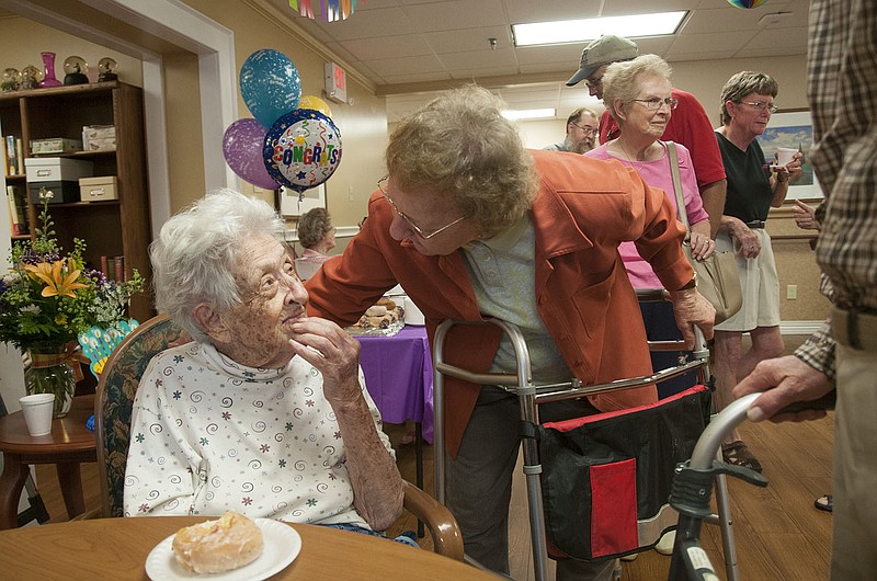 Martha McCray, a lifelong Callawegian who turns 100 years old today, smiles at friend wishing her a happy birthday Friday at Presbyterian Manor. Nearly 50 people attended the birthday party that the assisted living hosted for McCray.