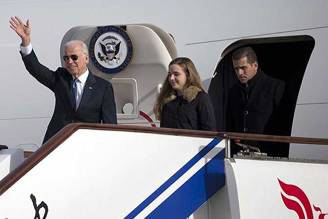 This Dec. 4, 2013, file photo shows U.S. Vice President Joe Biden, left, arriving on Air Force Two in Beijing, China, with his son Hunter Biden, right, and his granddaughter Finnegan Biden.