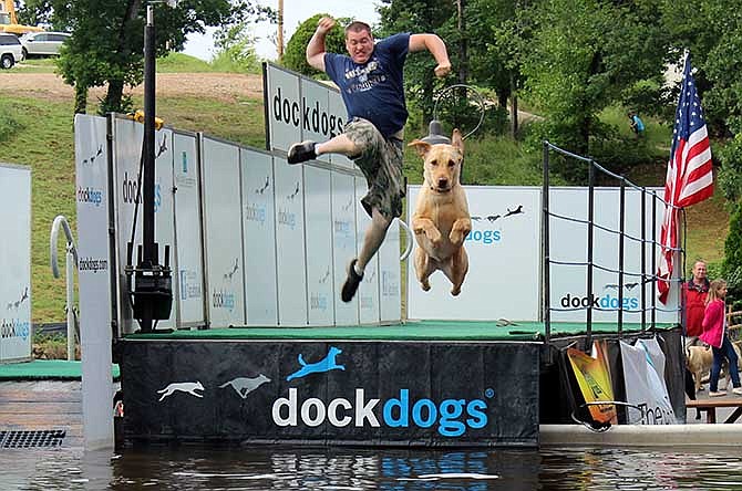 A canine competitor, motivated by his owner's enthusiasm, lifts off from the dock Saturday during the Canine Cannonball at Dog Days Bar & Grill.