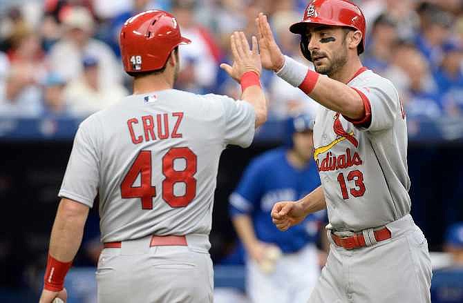 St. Louis Cardinals' Matt Carpenter, right, and Tony Cruz celebrate Carpenter's two-run home run against the Toronto Blue Jays during the second inning of a baseball game in Toronto, Sunday, June 8, 2014. 