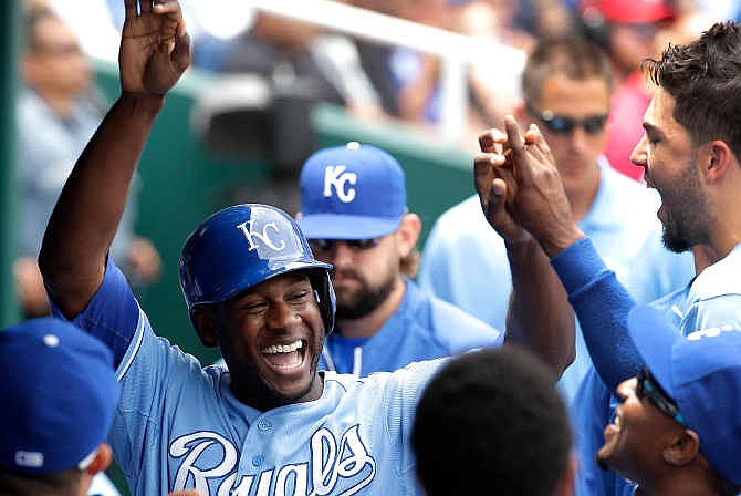 Kansas City Royals' Lorenzo Cain celebrates in the dugout after scoring on a single by Mike Moustakas during the second inning of a baseball game against the New York Yankees Sunday, June 8, 2014, in Kansas City, Mo.