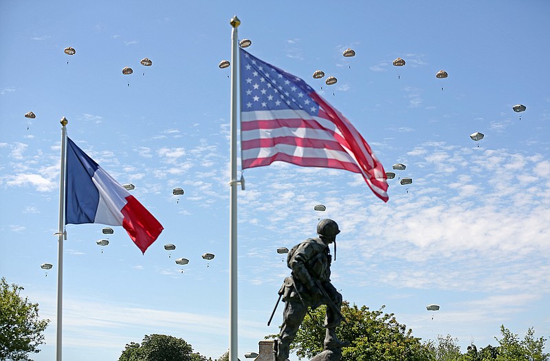 Paratroopers are dropped near the Normandy village of Sainte Mere Eglise, western France, during a mass air drop, Sunday as part of commemorations of the 70 anniversary of the D-Day landing.