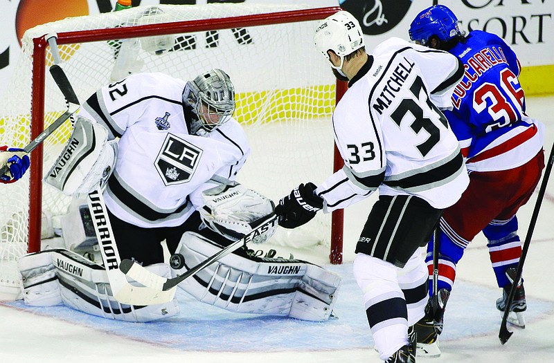 Jonathan Quick blocks a shot by Mats Zuccarello as Willie Mitchell helps defend during Monday night's Stanley Cup Final Game in New York. 