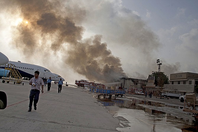 Smoke rises above Karachi airport terminal Monday in Pakistan. Gunmen disguised as police guards attacked the terminal with machine guns and a rocket launcher during a five-hour siege that killed 13 people as explosions echoed into the night.