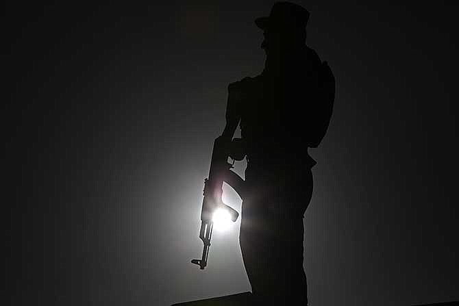 An Afghan police officer stands guard during a campaign rally in the Paghman district of Kabul, Afghanistan, Monday, June 9, 2014. 