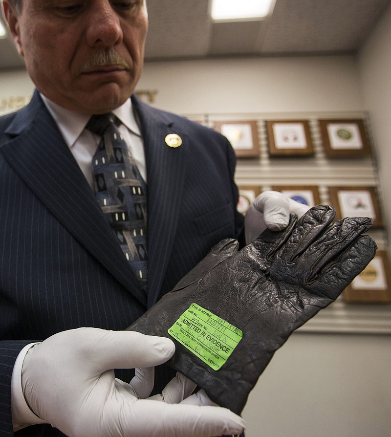 Los Angeles County District Attorney senior investigator John Calicchio shows a glove used as evidence in the O.J. Simpson murder case, in the DA's office in Los Angeles.