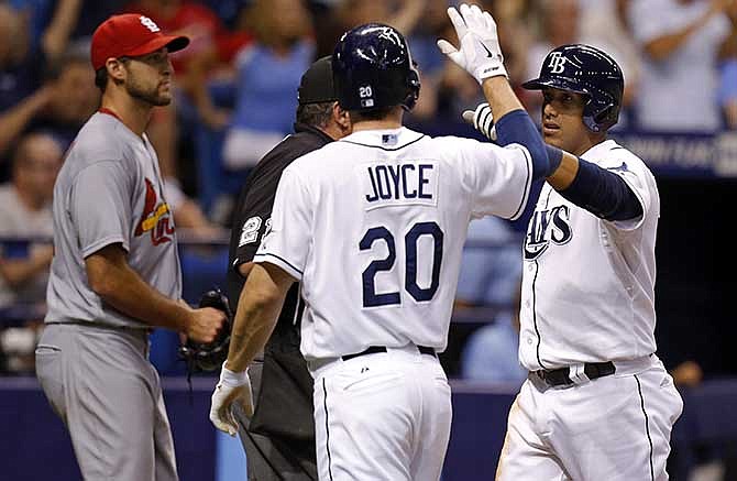 Tampa Bay Rays' Yunel Escobar, right, is celebrates with Matt Joyce after both scored on a single by Desmond Jennings during the fourth inning of a baseball game as St. Louis Cardinals starting pitcher Michael Wacha reacts in the background Wednesday, June 11, 2014, in St. Petersburg, Fla. 