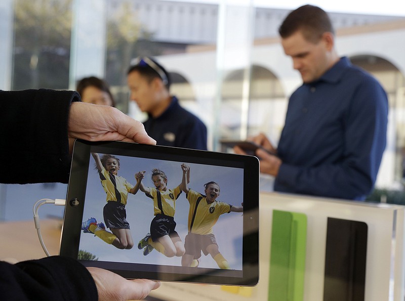 In this file photo, an iPad Air is posed for a photo in Stanford, Calif. Retailers are offering plenty of deals on the latest tech gifts, particularly mobile devices, that are topping dad's wish lists.