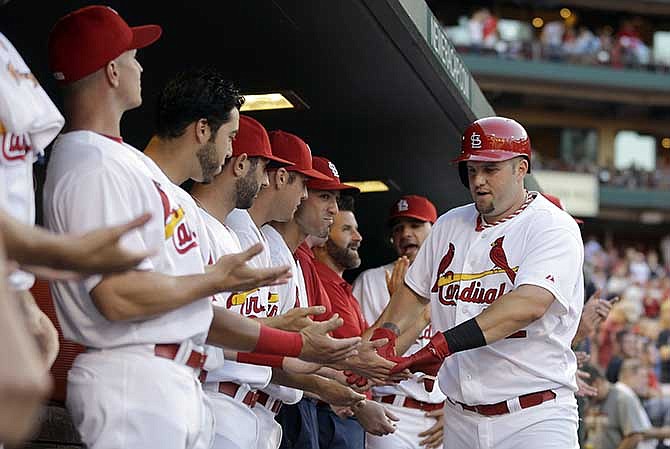 St. Louis Cardinals' Matt Adams, right, is congratulated by teammates after hitting a solo home run during the second inning of a baseball game against the Washington Nationals, Friday, June 13, 2014, in St. Louis.