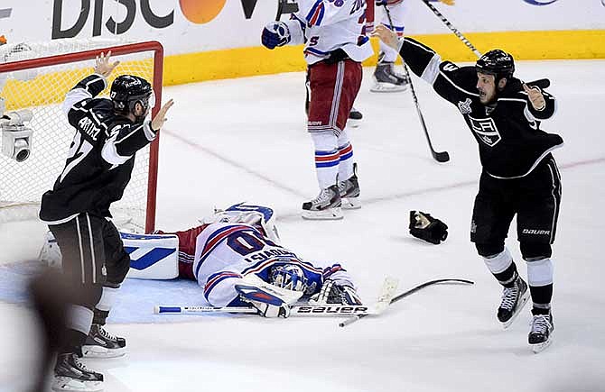 Los Angeles Kings defenseman Alec Martinez, left, celebrates with Kyle Clifford, right, after scoring the winning goal past New York Rangers goalie Henrik Lundqvist, of Sweden, during the second overtime period in Game 5 of an NHL hockey Stanley Cup finals, Friday, June 13, 2014, in Los Angeles. 