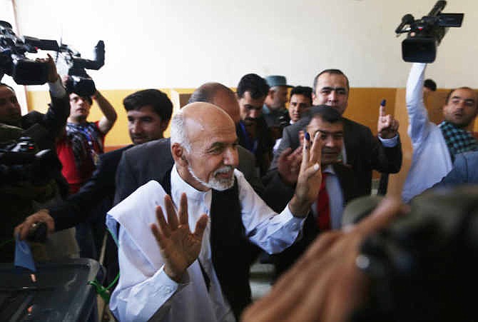 Afghanistan's presidential candidate Ashraf Ghani Ahmadzai, center, talks to media representatives after voting at a polling station in Kabul, Afghanistan, Saturday, June 14, 2014. Despite Taliban threats of violence, many Afghans vow to cast ballots in Saturday's presidential runoff vote with hopes that whoever replaces President Hamid Karzai will be able to provide security and stability after international forces wind down their combat mission at the end of this year.