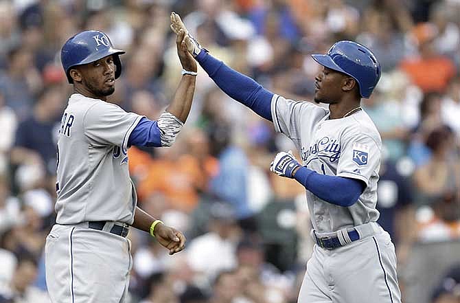 Kansas City Royals' Alcides Escobar, left, and Jarrod Dyson celebrate scoring on a Omar Infante single against the Detroit Tigers in the second inning of a baseball game in Detroit, Tuesday, June 17, 2014.