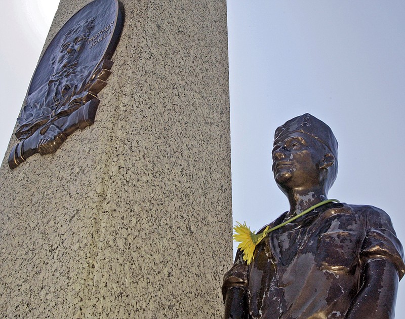 In this file photo, a single flower adorns the neck of one of the bronze miners on the monument at the grave of Mary "Mother" Jones in the Union Miners Cemetary in Mount Olive, Ill. The Illinois monument to the famed labor crusader is getting a makeover, thanks to donors in 17 states.