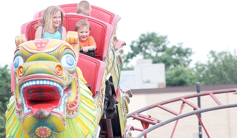 Mackenzie Wilson, 8, and Bryce Garrett, 3, both of Fulton take a ride on the Orient Express at the carnival Thursday in downtown Fulton.