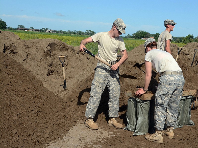 Soldiers from the South Dakota National Guard fill sandbags, Thursday at Dakota Valley Elementary School across from McCook Lake in North Sioux City, S.D.  Cities in Iowa, Nebraska, and South Dakota are fighting a surging Big Sioux River after heavy rain this week pushed the waterway to record levels in some locations.