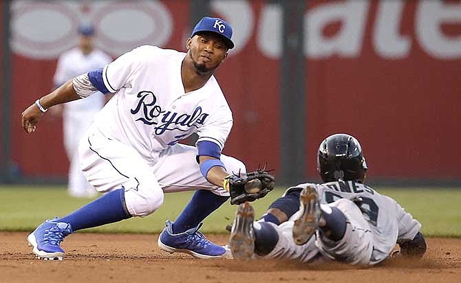 Seattle Mariners' James Jones beats the tag by Kansas City Royals shortstop Alcides Escobar, left, to steal second during the fifth inning of a baseball game Friday, June 20, 2014, in Kansas City, Mo.