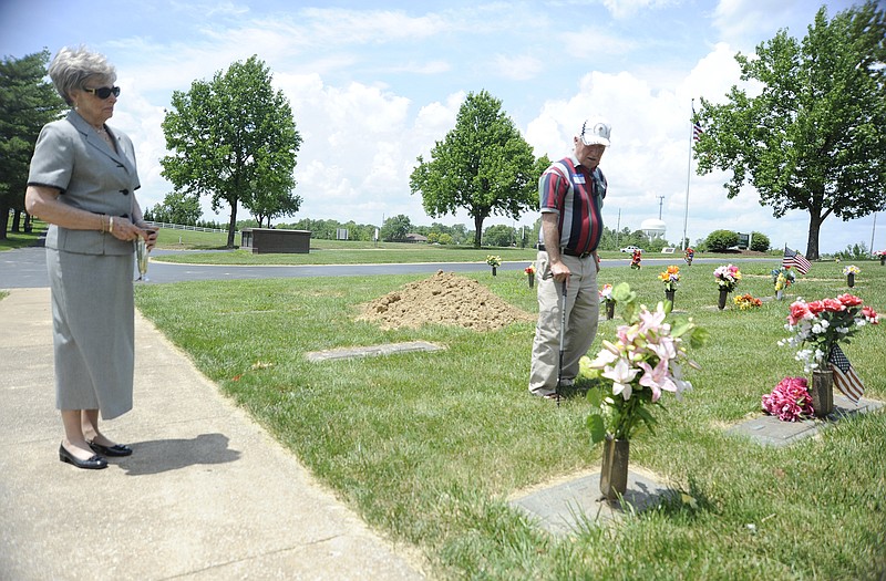 Randy Roby says a prayer at the Hudgins' family burial plot at Hawthorn Memorial Gardens after placing flowers on Michael Hudgins' memorial marker. Hudgins - along with Roby's brother, Tom - died in a plane wreck in the Jefferson City area in August 1967. He is accompanied by Sara Lou Brydon, a member of First Presbyterian Church, which was where the Hudgins' family worshipped.