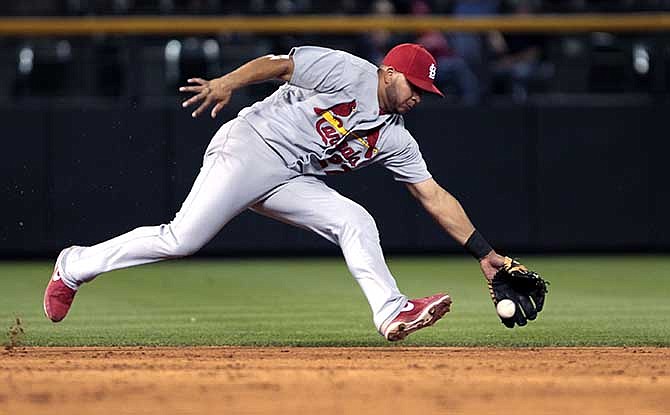 St. Louis Cardinals shortstop Jhonny Peralta fields a ground ball hit by Colorado Rockies' Brandon Barnes before throwing out Barnes at first base to end the sixth inning of a baseball game in Denver on Tuesday, June 24, 2014. 