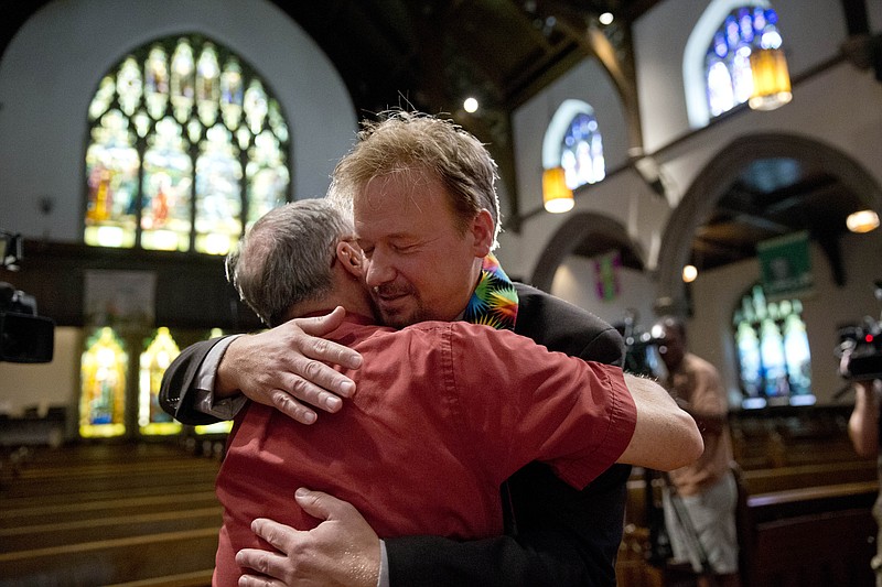 United Methodist pastor Frank Schaefer, right, hugs the Rev. David Wesley Brown after a news conference on Tuesday at First United Methodist Church of Germantown in Philadelphia. Schaefer, who presided over his son's same-sex wedding ceremony and vowed to perform other gay marriages if asked, can return to the pulpit after a United Methodist Church appeals panel on Tuesday overturned a decision to defrock him.