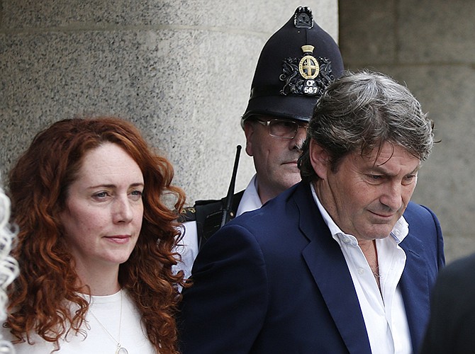 Rebekah Brooks, former News International chief executive, left, accompanied by her husband Charlie Brooks, leaves the Central Criminal Court in London on Tuesday. Former News of the World editor Andy Coulson was convicted of phone hacking Tuesday, but fellow editor Rebekah Brooks was acquitted after a months-long trial centering on illegal activity at the heart of Rupert Murdoch's newspaper empire.