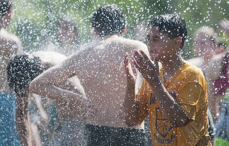 A College for Kids camper splashes water in his face Wednesday after an ice cream fight at the Fulton Fire Department on Westminster Ave. Fulton firefighters sprayed the children, covered in ice cream and syrup, from a fire engine. College for Kids Director Sue Craghead said the camp - from classes to recreational activties - has the purpose to "have fun in life, laugh at yourself, enjoy life and be kind to others."