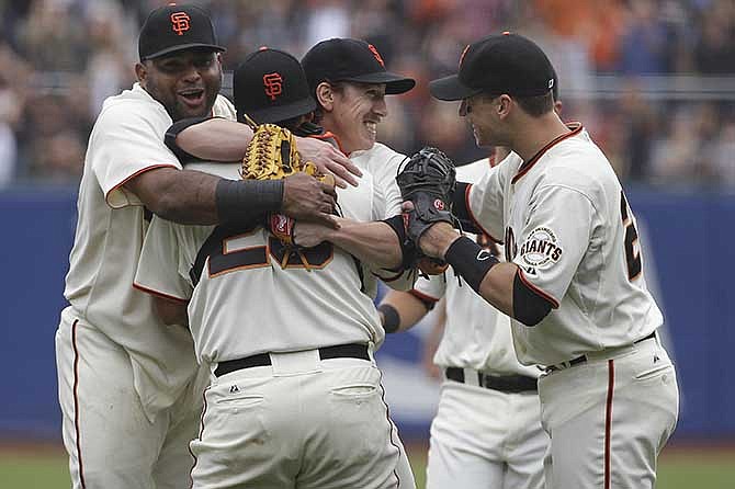 San Francisco Giants pitcher Tim Lincecum, center, is embraced by teammates, from left, Pablo Sandoval, catcher Hector Sanchez, and Buster Posey after throwing a no-hitter against the San Diego Padres a baseball game Wednesday, June 25, 2014, in San Francisco. Lincecum threw his second career no-hitter as San Francisco won 4-0. 