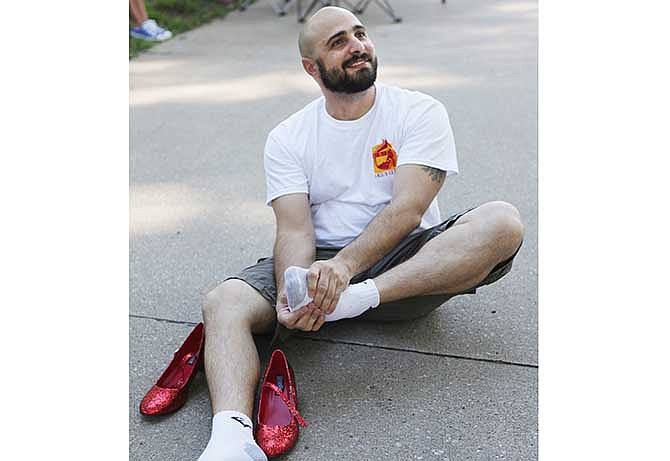 Ramon Llamas rubs his feet in preparation for the pain he expects after walking a mile in high heels for the Walk A Mile in Her Shoes event Tuesday at Memorial Park. The event is put on by the Jefferson City Rape and Abuse Crisis Service and helps bring awareness and funds to funds to support of domestic and sexual violence victims.
