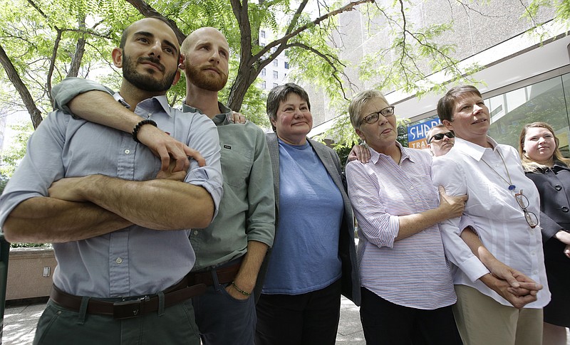 Five of the six people who brought the lawsuit against the Utah's gay marriage ban, stand together at a news conference outside their lawyers office Wednesday, in Salt Lake City. On Wednesday, a federal appeals court in Denver ruled that states must allow gay couples to marry, finding the Constitution protects same-sex relationships. The decision from a three-judge panel in Denver upheld a lower court ruling that struck down Utah's gay marriage ban.