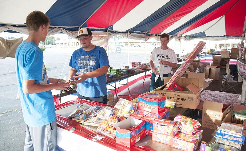 Grayson Peneston, 16, of Fulton sells fireworks to a patron Thursday evening off of North Bluff Street.