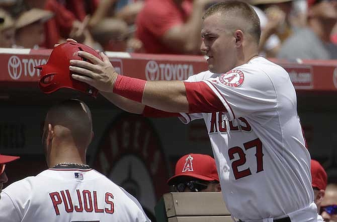 Los Angeles Angels' Albert Pujols, left, celebrates with Mike Trout after scoring on a hit by Erick Aybar against the Minnesota Twins during the first inning of a baseball game in Anaheim, Calif., Thursday, June 26, 2014.