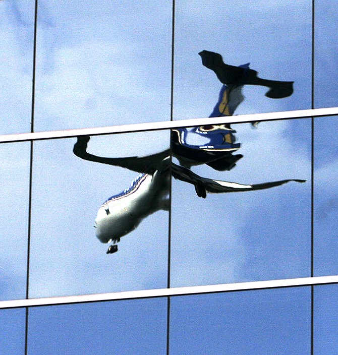 A twisted reflection of a passenger jet is shown in the mirrored windows of an office building as it lands at Washington's Reagan National Airport in Roslyn, Virginia. The government wants to dramatically reduce the height limits of buildings near hundreds of airports, but the proposal is drawing fire from real estate developers, local business leaders and members of Congress who say it will reduce property values. 