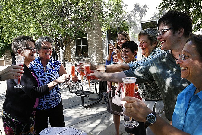 Longtime same-sex couple Angie Holley, far left, and Bylo Farmer share a toast with friends celebrating with their new marriage license, in front of the offices of the Boulder County Clerk and Recorder, in Boulder, Colorado. Together eight years, Holley and Farmer decided to become officially married after Boulder County Clerk Hillary Hall began issuing licenses a day earlier following a federal appeals court ruling that Utah's same-sex marriage ban is unconstitutional. 