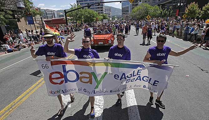 In this June 8, 2014, photo, workers carry an eBay banner during the gay pride parade, in Salt Lake City. Corporations have increased visibility this summer at gay pride parades around the country as same-sex marriage bans fall in the courts and polls show greater public acceptance of gay marriage.