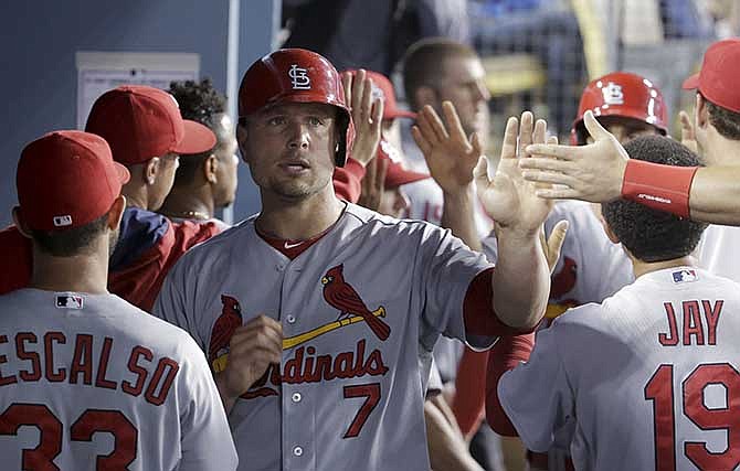 St. Louis Cardinals' Matt Holliday celebrates in the dugout after scoring on a two-run double by Jhonny Peralta during fifth inning of a baseball game in Los Angeles, Friday, June 27, 2014. 