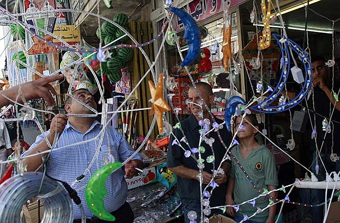 A Palestinian vendor displays Ramadan decorations at a market ahead of Ramadan in the West Bank city of Jenin on Saturday, June 28, 2014. Ramadan, for observant Muslims, is a time of fasting, prayer and charitable giving. 