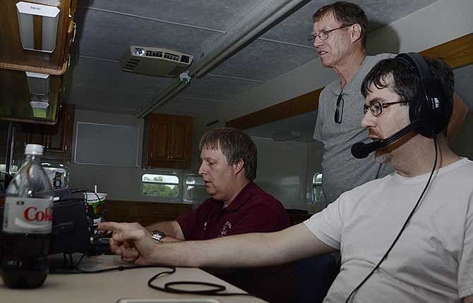 Jerry Sill, center, listens as Mike Eberle, right, and Mike Miller, left, communicate with a radio operator at the Yuri
Gargarin Cosmonaut Training Center in Russia during Ham Radio Field Days.
