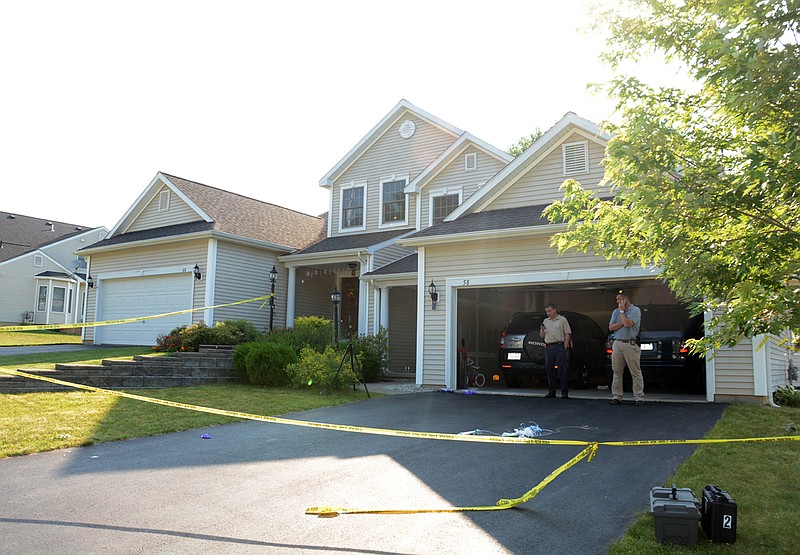 Detectives work Tuesday at the house in East Greenbush, N.Y. where a mother, despondent over her son's suicide, killed her two young daughters and herself using suffocating nitrogen gas at their home, about a week after a stay in a mental institution, authorities said.