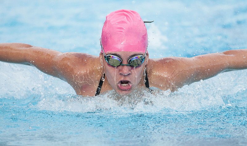 Kaylee English, 12-year-old Fulton Fins swimmer, swims the butterfly stroke in the 100 IM Wednesday at the Oestreich Municipal Swim Pool. After the loss of two grandparents to cancer, English decided she wanted to fundraise for the American Cancer Society, and the Fulton Fins hosted "Splash Out Cancer" during its regularly scheduled meet on Wednesday. Male and female swimmers wore pink swim caps to show support of breast cancer awareness.