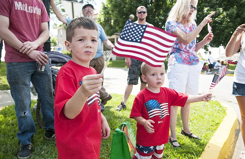 Brothers Charlie Ross, 5, and John Ross, 2, of Fulton wave American flags as the Independence Day Parade goes down Court Street on Friday.