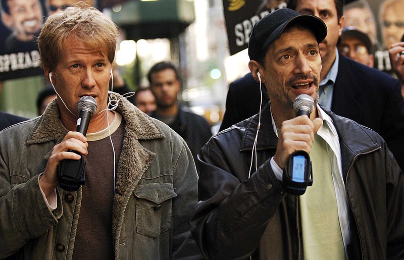 In a April 26, 2006 file photo, radio shock jocks Greg "Opie" Hughes, left, and Anthony Cumia, right, leave CBS Radio studios on 57th Street with fans after finishing their first morning show, in New York. Cumia of the "Opie & Anthony" radio show was fired late Thursday, July 3, 2014 by SiriusXM, who cited his "racially charged" and "hate-filled" remarks on Twitter as the reason.