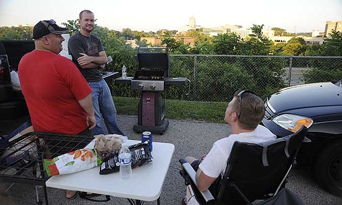 Andrew Clayton, Bryce Branson and Jared Acklie staked out their spot for the Jefferson City's fireworks display Friday night at the Missouri National Guard armory. To add to their "backyard experience," they grilled up brats and stuffed burgers and brought pie and sweet potato chips to pass the hours beforehand. 