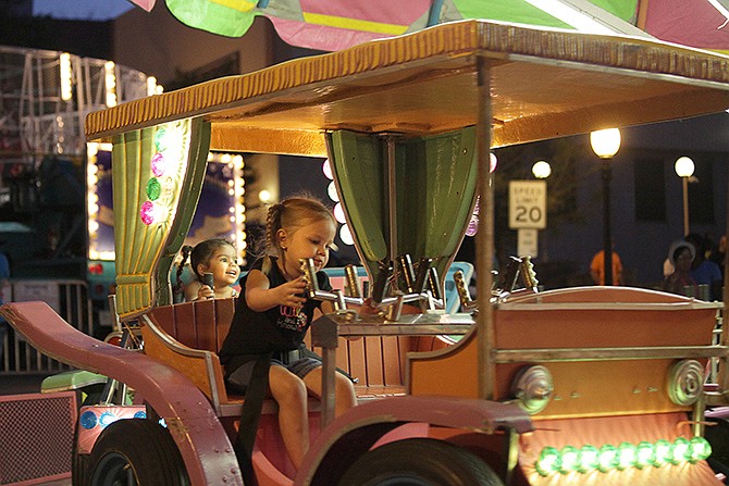 Maycee Rogers, 3, front, "drives" her car while Trinity Gates, 2, back, does the same during a carnival ride at Salute to America on July 3. The carnival rides ranged from simple children's rides like this, to those that caused shrieks from both children and adults as they were spun through the air. 