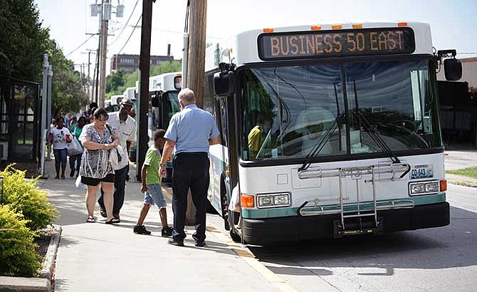 George Mincher helps riders July 1, 2014, onto the JeffTran bus he drives at the Transit Division offices on Miller Street. 