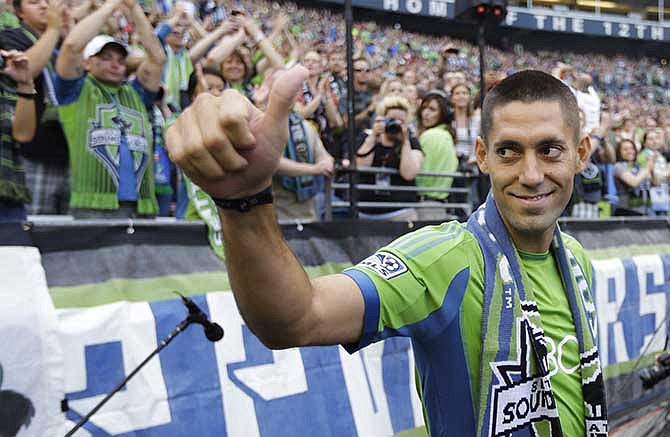 In this Aug. 3, 2013 file photo, Clint Dempsey greets fans after he was introduced as the newest member of the Seattle Sounders FC MLS soccer team, in Seattle. From Seattle to Salt Lake City, the California cities of Los Angeles and San Jose, from Kansas City to Houston and up to Toronto, die-hard fans watched their local stars in soccer's showcase event. 