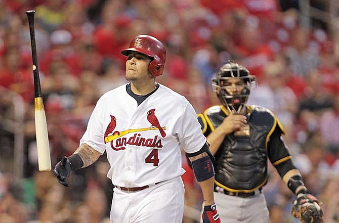 St. Louis Cardinals' Yadier Molina (4) tosses his bat in frustration after being called out on strikes as Pittsburgh Pirates catcher Russell Martin looks on in the fourth inning of a baseball game, Tuesday, July 8, 2014 in St. Louis. 