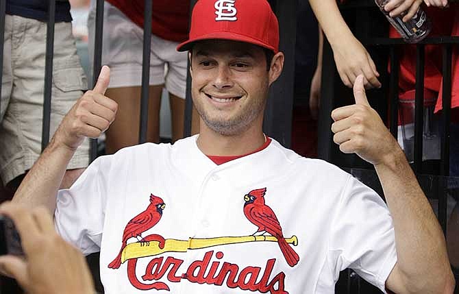 St. Louis Cardinals starting pitcher Joe Kelly poses for a fan photo during a rain delay at a baseball game between the Cardinals and the Philadelphia Phillies, Friday, June 20, 2014, in St. Louis. 