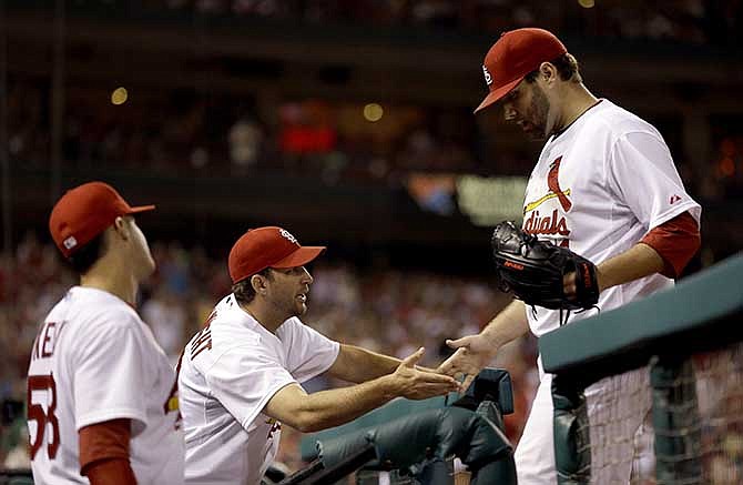 St. Louis Cardinals starting pitcher Lance Lynn, right, is congratulated by teammates Adam Wainwright, center, and Joe Kelly, left, after being removed from a baseball game against the Pittsburgh Pirates during the seventh inning Wednesday, July 9, 2014, in St. Louis. 