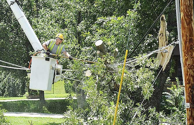 Jefferson City's west side had several power outages as trees and branches fell over electric lines, as shown here on Henwick Lane. Daniel Hager used a chainsaw to cut the branches off the lines Tuesday so Ameren crews could work to return service. Hager and others from The Shade Tree Service Company of Fenton, Mo., started at 4 a.m. to clear debris from the previous night's heavy winds.