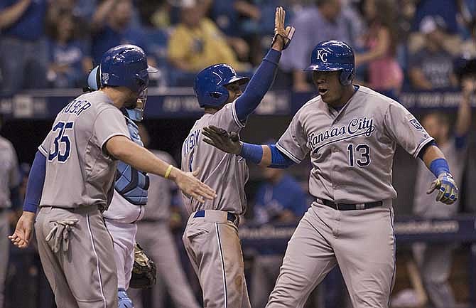 Kansas City Royals' Eric Hosmer (35) and Jarrod Dyson, center, celebrate after scoring on a three-run homer by Salvador Perez (13) off Tampa Bay Rays reliever Kirby Yates during the ninth inning of a baseball game Wednesday, July 9, 2014 in St. Petersburg, Fla. The Royals beat the Rays 5-4.